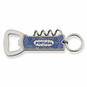 A silver metal keychain with an attached blue bottle opener featuring a decorative design. The multifunctional opener includes a corkscrew, a flat bottle cap opener, and a compact knife. This elegant souvenir stands out against its plain white background.