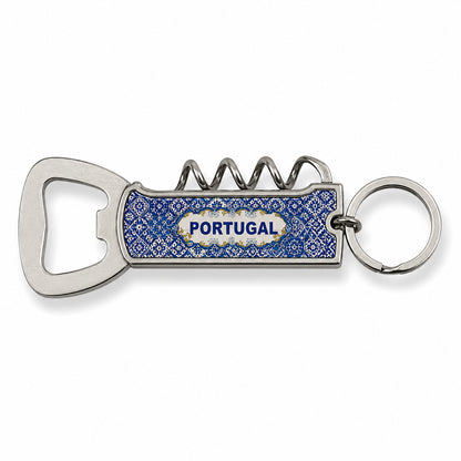 A silver metal keychain with an attached blue bottle opener featuring a decorative design. The multifunctional opener includes a corkscrew, a flat bottle cap opener, and a compact knife. This elegant souvenir stands out against its plain white background.