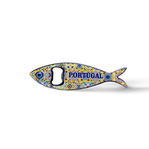 A fish-shaped metal bottle opener with intricate, colorful patterns is displayed against a plain background. The word "PORTUGAL" is prominently featured in blue on the sardine's body. This charming souvenir also doubles as a magnet, making it a perfect keepsake for your fridge.