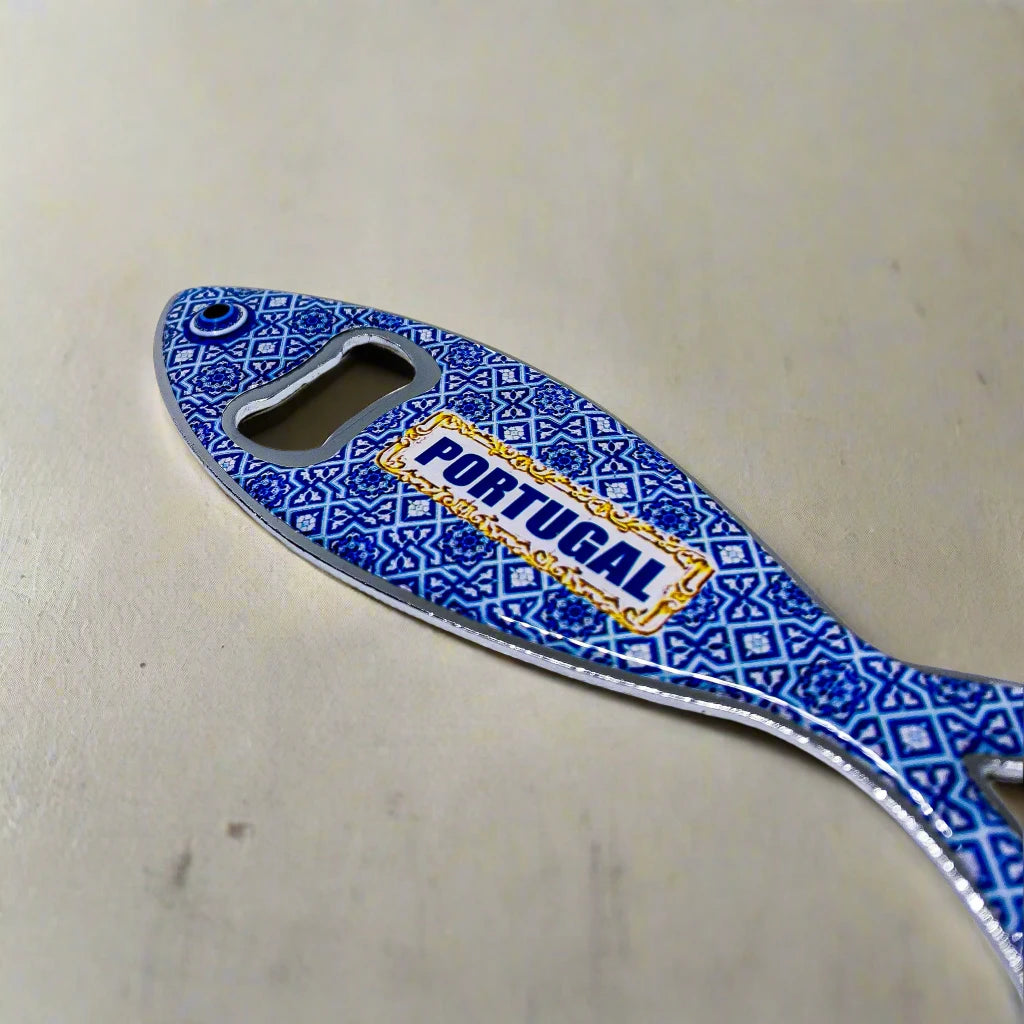 A sardine-shaped metal bottle opener with intricate and colorful patterns, showcasing "PORTUGAL" in blue. This souvenir doubles as a fridge magnet, blending practicality with a touch of Portuguese flair.