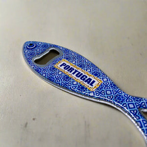 A sardine-shaped metal bottle opener with intricate and colorful patterns, showcasing "PORTUGAL" in blue. This souvenir doubles as a fridge magnet, blending practicality with a touch of Portuguese flair.