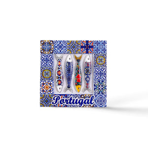 A decorative tile magnet features four fish adorned with colorful patterns, set against a backdrop of intricate blue and white azulejo designs. The word "Portugal" is written in blue cursive at the bottom, making it a charming souvenir.