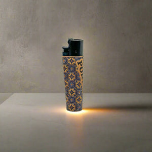 A lighter showcasing intricate patterns with "PORTUGAL" written vertically along the side. The top is black, while the base features an orange and black design inspired by traditional cork patterns. Set against a plain white background, this lighter stands out as a stylish souvenir.