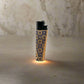 This lighter features detailed patterns, with "PORTUGAL" written vertically along the side. The black top contrasts with the decorative base, which has an orange and black pattern reminiscent of classic cork designs. The white background highlights the lighter's unique style.