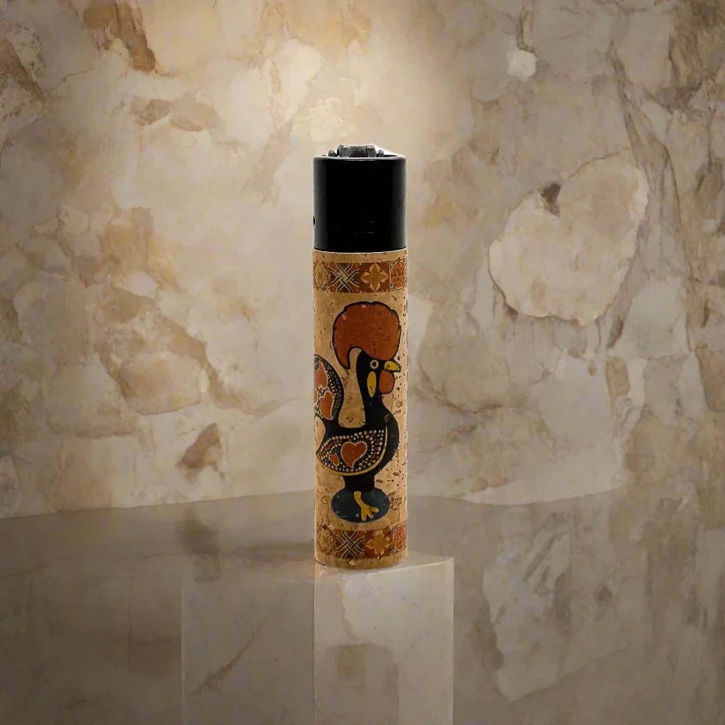 A souvenir lighter wrapped in a decorative design featuring the word "PORTUGAL" alongside traditional Portuguese artwork, including a vibrant rooster. The lighter's black top contrasts with the colorful wrap.