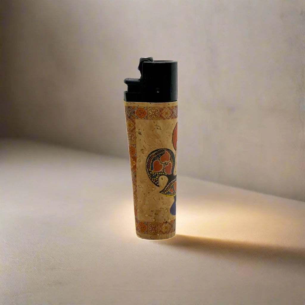 A souvenir lighter adorned with traditional Portuguese artwork, including a vibrant rooster and the word "PORTUGAL" displayed prominently. The lighter features a black top.