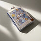 A stainless steel flask decorated with a mix of blue, yellow, and white tile patterns, with "PORTUGAL" prominently featured in the center. The cap is secured by a small hinge, adding practicality to this stylish souvenir. The flask sits on a white background, casting a subtle shadow to one side.