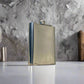 A stainless steel flask decorated with a mix of blue, yellow, and white tile patterns, with "PORTUGAL" prominently featured in the center. The cap is secured by a small hinge, adding practicality to this stylish souvenir. The flask sits on a white background, casting a subtle shadow to one side.