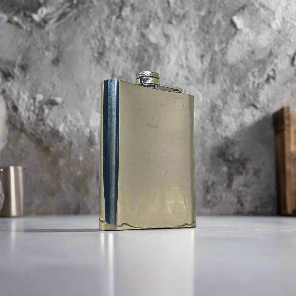 A stainless steel flask decorated with a mix of blue, yellow, and white tile patterns, with "PORTUGAL" prominently featured in the center. The cap is secured by a small hinge, adding practicality to this stylish souvenir. The flask sits on a white background, casting a subtle shadow to one side.