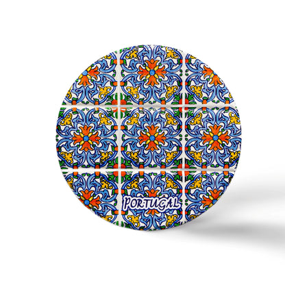 A round cork coaster adorned with colorful, detailed tile motifs in blue, yellow, and green. "Portugal" is inscribed near the bottom in a stylish font, and the minimalistic white background enhances the beauty of this perfect Portuguese souvenir.