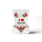 A curvy hourglass-shaped shot glass souvenir features the text "I ❤️ PORTUGAL" surrounded by images of pink flamingos and red flowers. The design is colorful and vibrant, showcasing the love for Portugal.