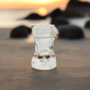 A colorful hourglass-shaped shot glass souvenir displays the text "I ❤️ PORTUGAL" along with vibrant pink flamingos and red flowers. Its lively design captures a spirited love for Portugal.