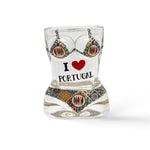 The shot glass, with its curvy hourglass shape, boasts the message "I ❤️ PORTUGAL" framed by vivid pink flamingos and red flowers. Its bright and lively design celebrates Portugal with flair.