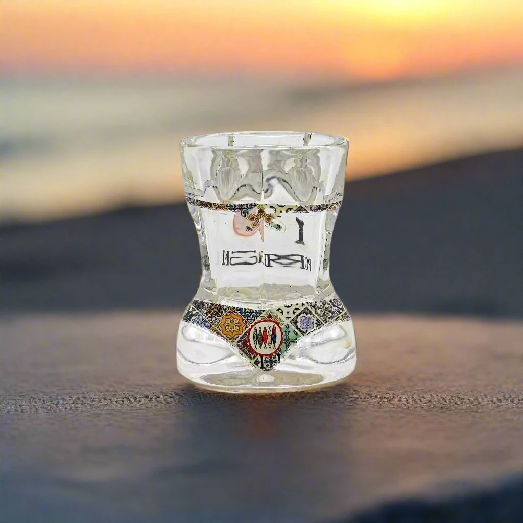A lively hourglass-shaped shot glass showcases "I ❤️ PORTUGAL" surrounded by bright pink flamingos and red flowers, reflecting a colorful and enthusiastic admiration for Portugal.