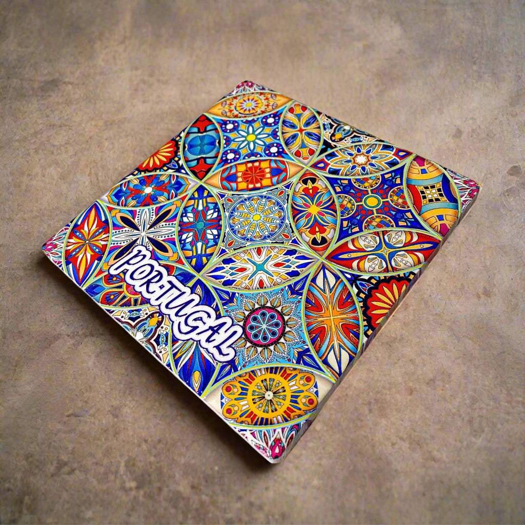 A vibrant ceramic tile design with intricate geometric and floral patterns in bold colors, primarily blue, yellow, and red. "PORTUGAL" stands out in white against the colorful backdrop, making it an ideal souvenir or a unique addition to any cork coaster collection.