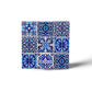This detailed ceramic tile features a mix of vivid geometric and floral designs, with dominant hues of blue, and white. The word "PORTUGAL" is highlighted in white, making it a perfect memento for travelers or a striking addition to a cork coaster set.