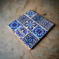 This intricate ceramic tile showcases a blend of vibrant geometric and floral patterns, primarily in shades of blue and white. The word "PORTUGAL" stands out in white, making it an ideal keepsake for travelers or a standout piece for any cork coaster collection.