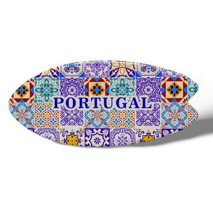 An oval-shaped ceramic object with a colorful mosaic pattern featuring traditional Portuguese azulejo tiles. The word "PORTUGAL" is prominently displayed in the center in blue uppercase letters. The souvenir features a cork base and casts a faint shadow on a white background.