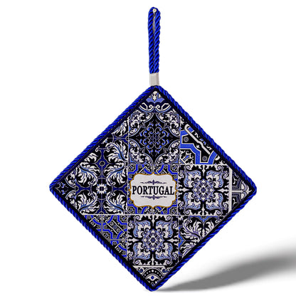 A square-shaped ceramic tile with a blue and white intricate pattern featuring the word "Portugal" in the center. The tile is framed with a blue braided cord, has a cork base for added durability, and includes a loop at the top for hanging.