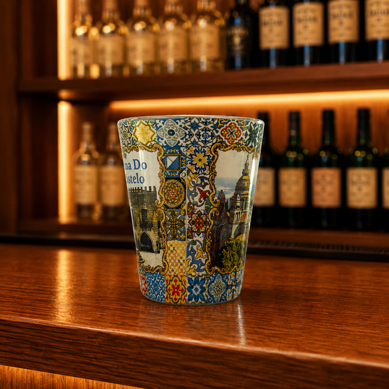 Viana do Castelo souvenir shot glass featuring Santa Luzia Sanctuary illustrations and colorful Portuguese azulejo tile artwork displayed on a wooden counter