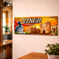 Viseu metal souvenir sign mounted on a wall featuring the cathedral, historic buildings and a monument statue with warm sunset tones