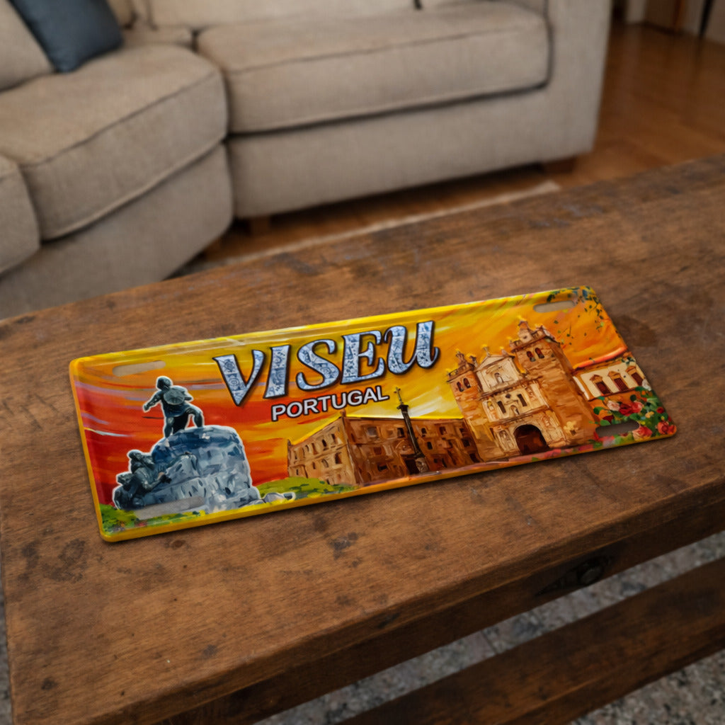 Viseu metal souvenir sign placed on a wooden table showing the cathedral, statue and city architecture in a vibrant illustration