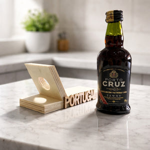 Wooden inclined stand with Portugal lettering placed next to the Porto Cruz Tawny Port wine bottle.
