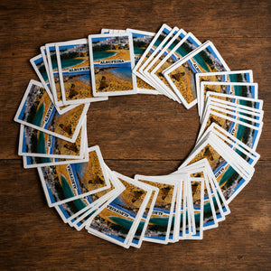 Albufeira souvenir playing cards arranged in a circular display showing Portugal-themed beach illustrations.