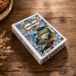 Algarve Portugal souvenir playing card box on a wooden table, featuring blue azulejo tiles, decorative sardines, and a traditional fishing boat scene.