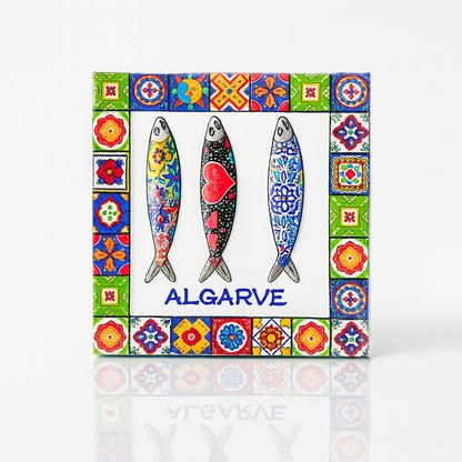 Square Algarve magnet made of resin, featuring three decorative sardines with colorful folk patterns, framed by a border of traditional Portuguese tiles