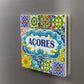 Decorative tile with colorful patterns and 'Açores' text on a metallic surface