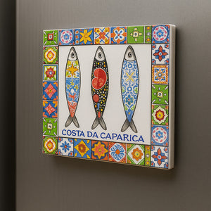 Decorative tile with three fish illustrations and a colorful border on a gray background