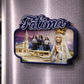 Fátima souvenir magnet placed on a fridge featuring Our Lady of Fátima, the sanctuary basilica, and the three shepherd children in Portugal