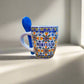 A beautifully designed ceramic coffee cup adorned with blue and white patterns, a delightful souvenir from Portugal.