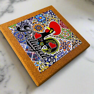 Cork coaster with colorful design featuring a rooster and text on a marble surface
