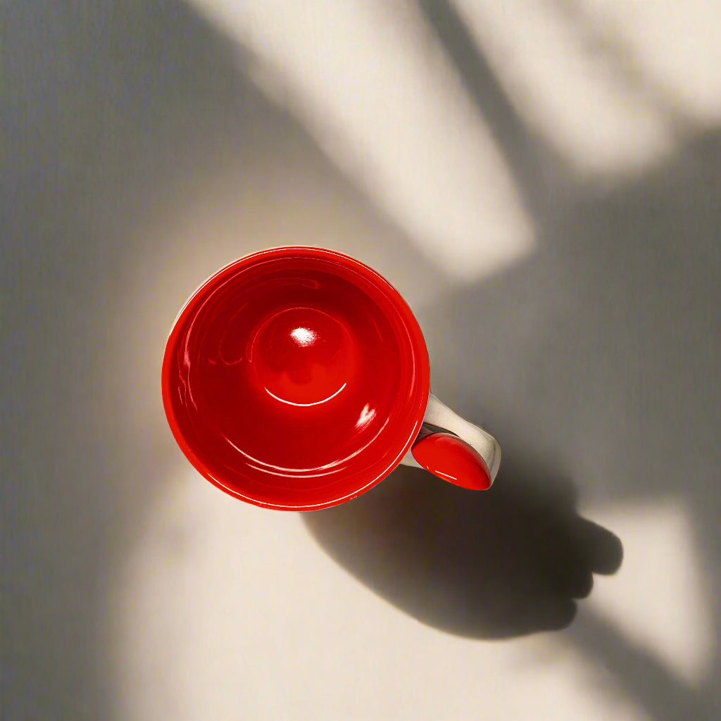 Red mug on a gray surface with a white wall in the background