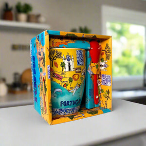 Colorful mug with 'Portugal' text in a decorative box on a desk.