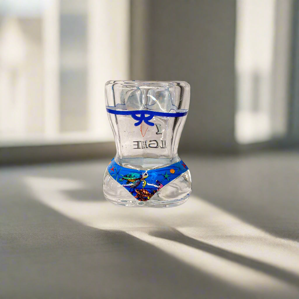 Clear glass object with colorful design and blue ribbon on a white surface