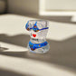Clear glass with colorful design and text on a white surface