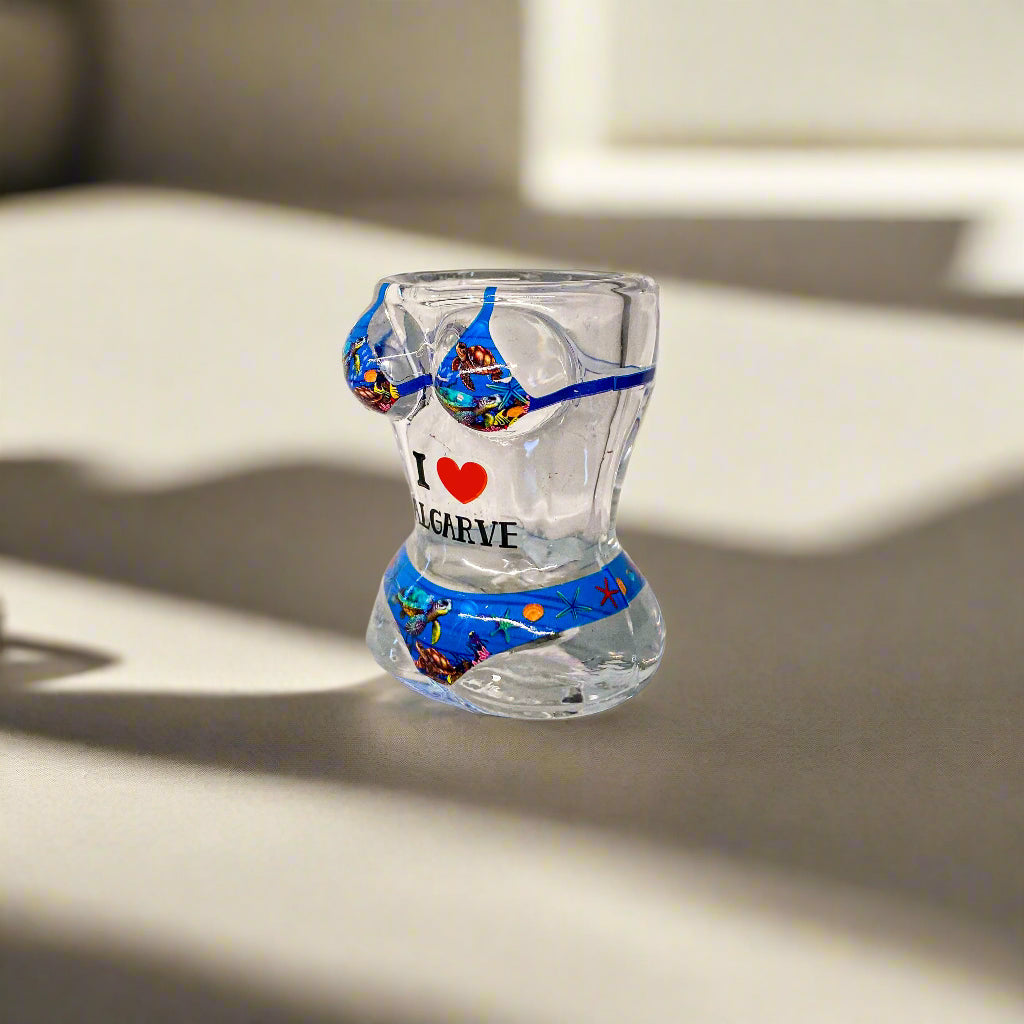 Clear glass with colorful design and text on a white surface