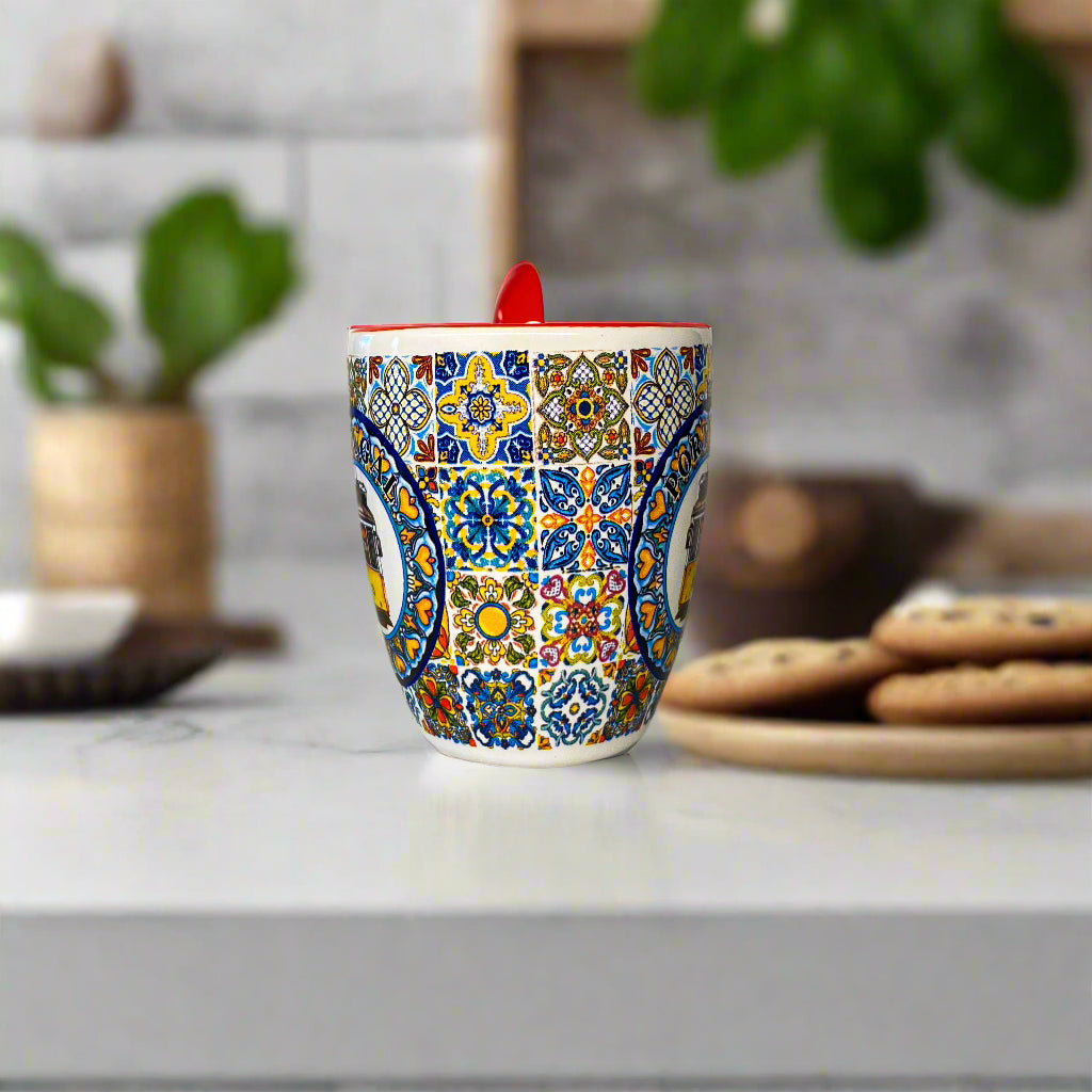 Colorful patterned mug with a red handle on a plain surface