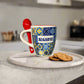 Mug with 'Algarve' text and colorful pattern next to a red spoon on a white surface.