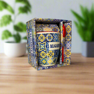 Decorative mug with colorful patterns in a matching box on a neutral background