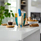 Colorful mug with a blue spoon on a light surface
