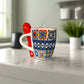 Colorful mug with 'Portugal' text and a red spoon on a light surface.