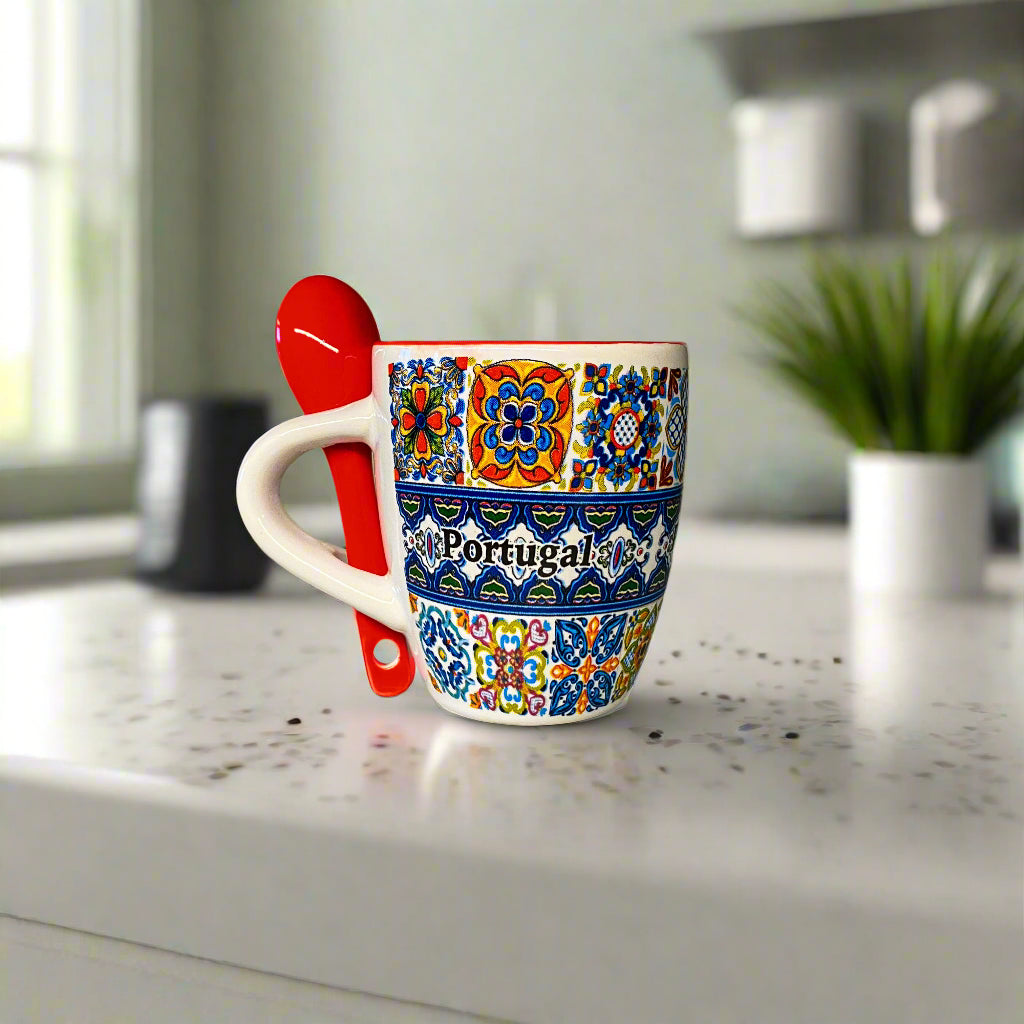Colorful mug with 'Portugal' text and a red spoon on a light surface.
