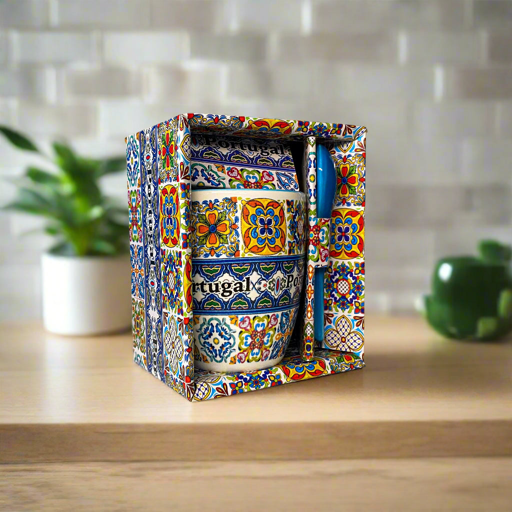 Decorative ceramic mug with colorful patterns in a box on a neutral background