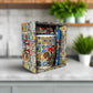 Decorative mug with colorful patterns in a matching box on a light surface.
