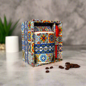 Colorful ceramic mug with 'Portugal' text in a decorative box on a table.