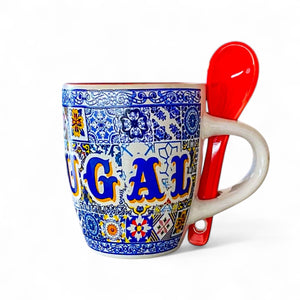 Decorative coffee cup with colorful patterns and a red spoon on a white background